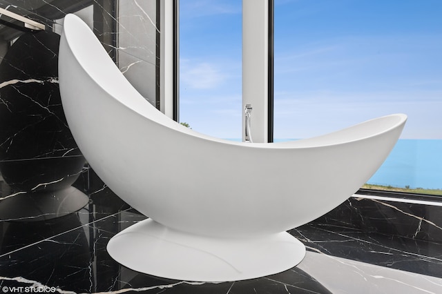 bathroom featuring plenty of natural light and tile walls