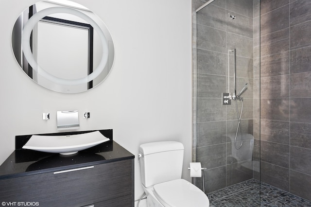 bathroom featuring vanity, toilet, and a shower with door