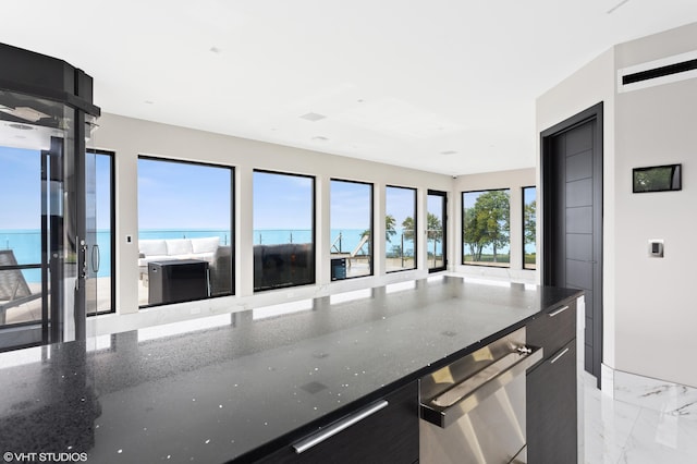 kitchen with a water view and dark stone counters