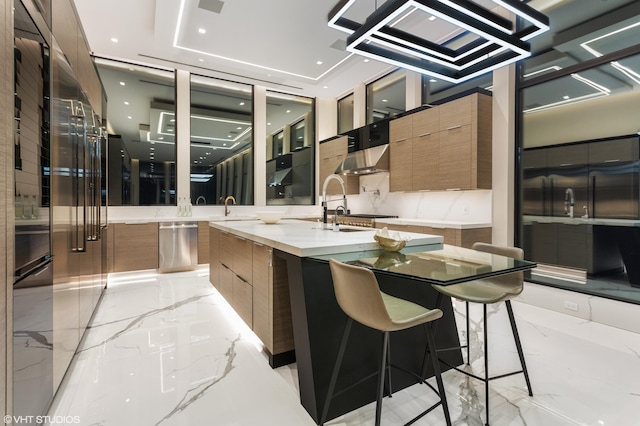 kitchen with a kitchen bar, a large island with sink, sink, and range hood