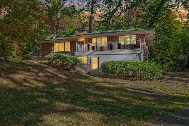 view of front of house with a yard and a balcony