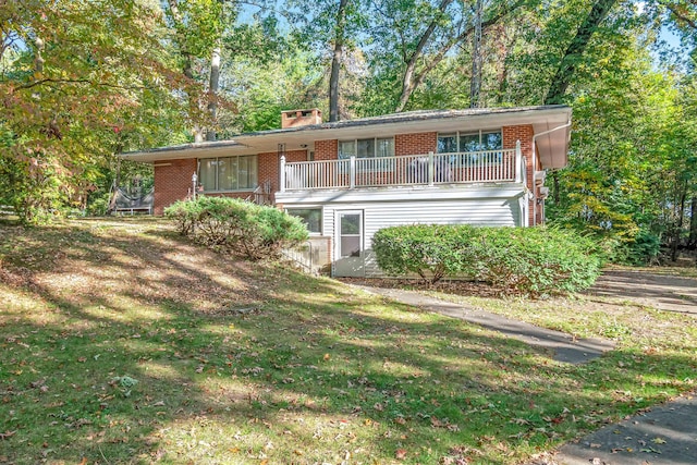 view of property with a front lawn and a balcony