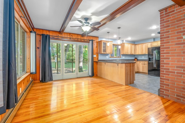 kitchen with beam ceiling, light hardwood / wood-style flooring, black refrigerator with ice dispenser, decorative light fixtures, and kitchen peninsula