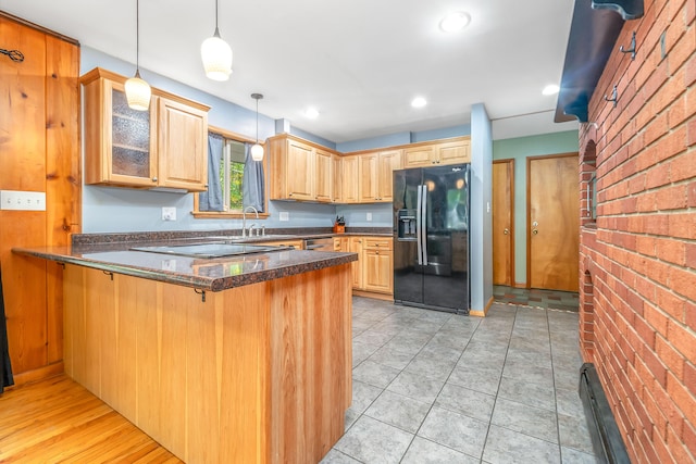 kitchen with pendant lighting, sink, kitchen peninsula, brick wall, and black appliances