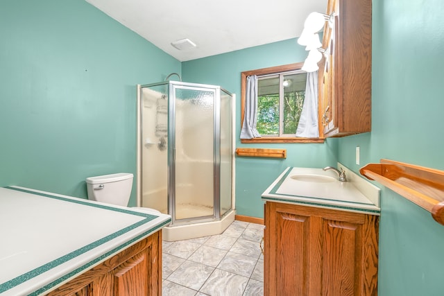 bathroom featuring vanity, toilet, an enclosed shower, and tile patterned floors