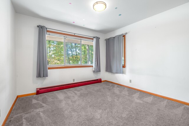 carpeted spare room with a baseboard radiator