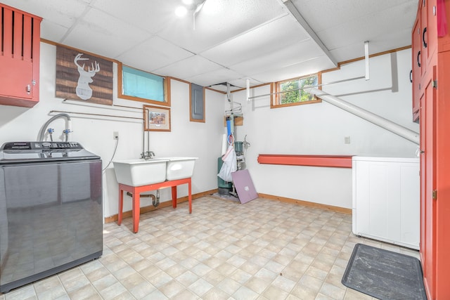 clothes washing area with washer and dryer, cabinets, and sink