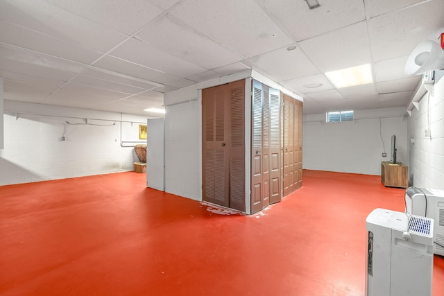 basement featuring a drop ceiling and a wealth of natural light