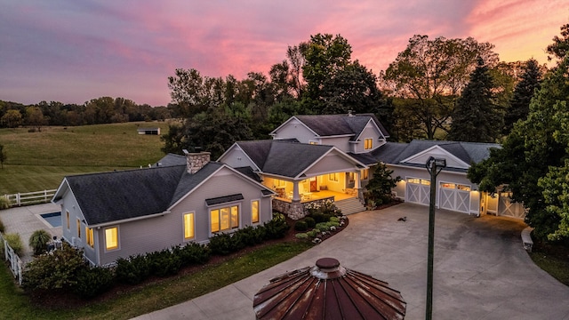 view of front of property with a garage, a porch, and a lawn