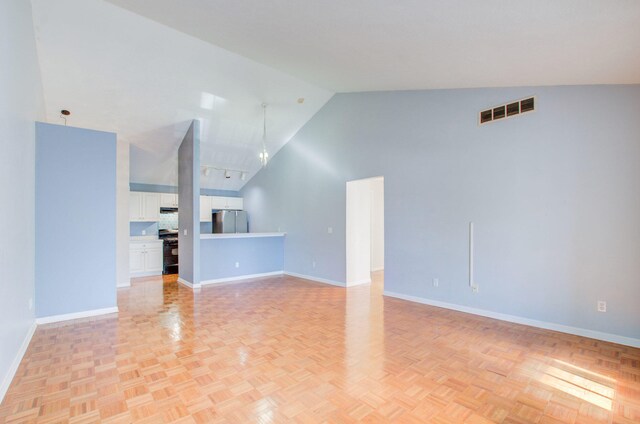 unfurnished living room with high vaulted ceiling and light parquet flooring