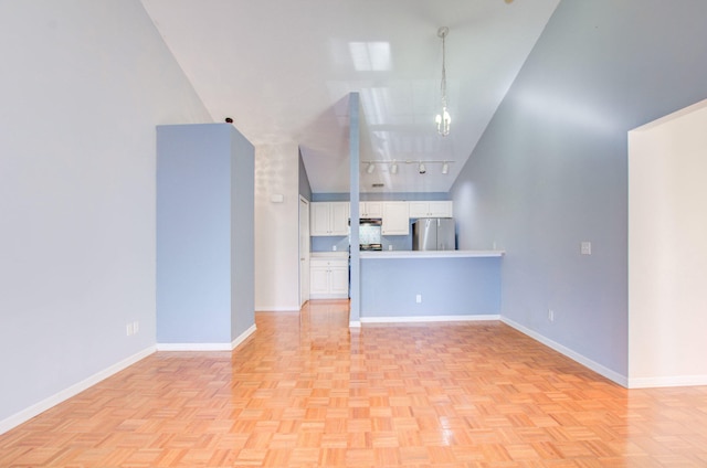 unfurnished living room with rail lighting, high vaulted ceiling, and light parquet floors