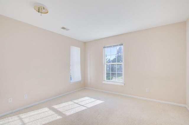 spare room featuring light carpet