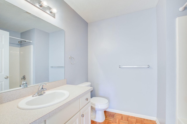 bathroom with walk in shower, vanity, toilet, and parquet floors