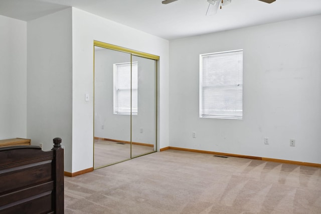 bedroom with a closet, light colored carpet, and ceiling fan