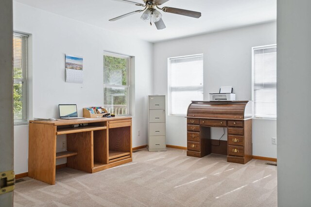 carpeted home office featuring ceiling fan