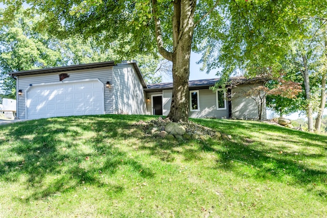 single story home featuring a garage and a front lawn