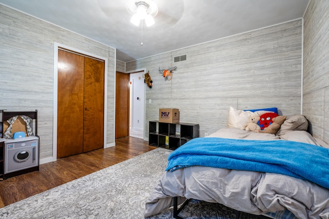 bedroom featuring ceiling fan, dark wood-type flooring, and a closet