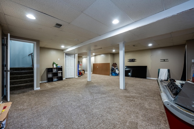 basement with a paneled ceiling and carpet flooring