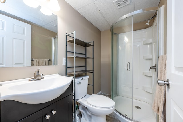 bathroom with toilet, vanity, and a shower with shower door