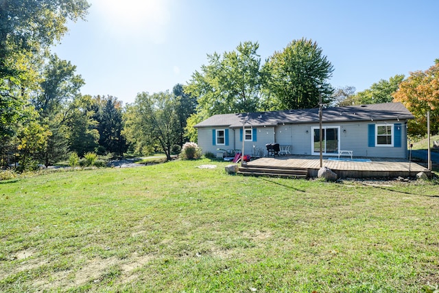 back of property with a yard and a wooden deck