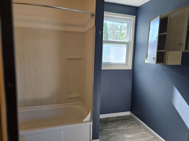 bathroom featuring wood-type flooring and  shower combination