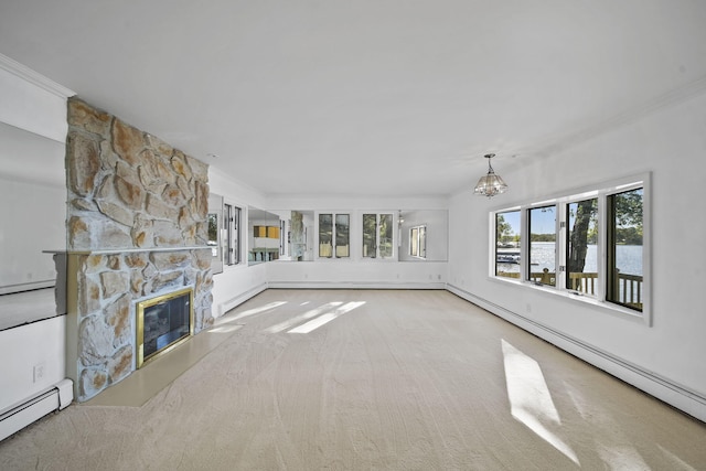 unfurnished living room featuring carpet, an inviting chandelier, a stone fireplace, ornamental molding, and a baseboard heating unit