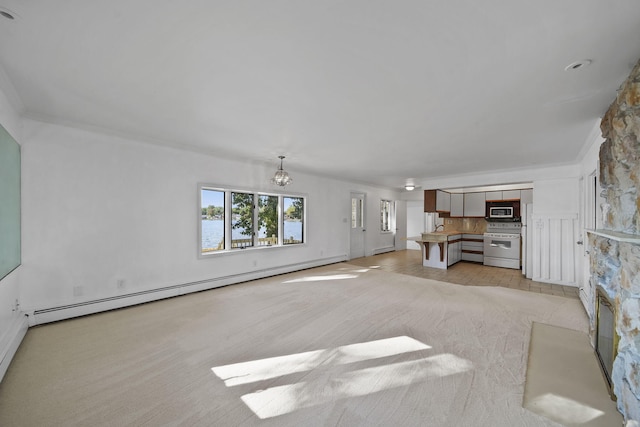 unfurnished living room with light colored carpet, a notable chandelier, ornamental molding, and a baseboard heating unit