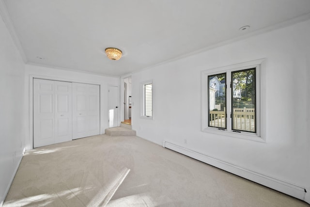 unfurnished bedroom with light colored carpet, a baseboard radiator, a closet, and crown molding