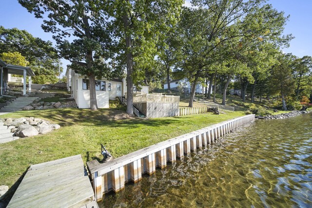 dock area featuring a water view and a lawn