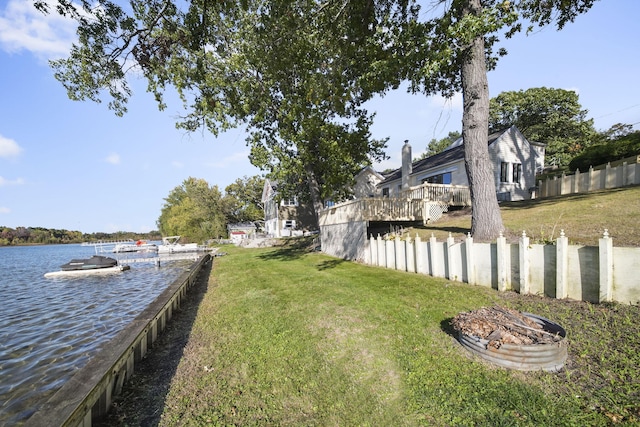 view of yard with a deck with water view and an outdoor fire pit