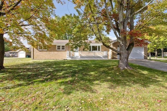 ranch-style home with a garage, a front lawn, and covered porch