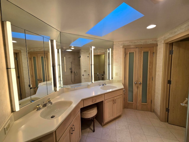 bathroom with tile patterned flooring, vanity, walk in shower, and a skylight