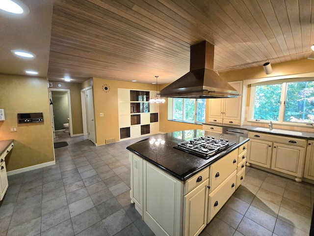 kitchen featuring island exhaust hood, a wealth of natural light, a kitchen island, and gas stovetop