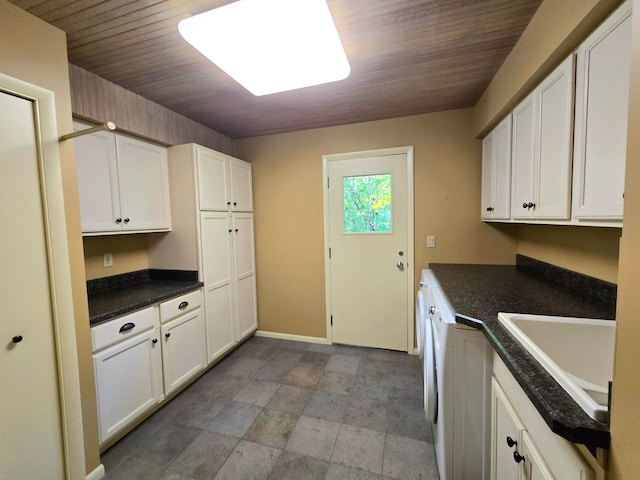 kitchen with white cabinets, wood ceiling, and sink