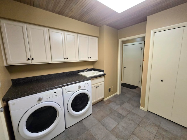 laundry area with washing machine and clothes dryer, sink, and cabinets