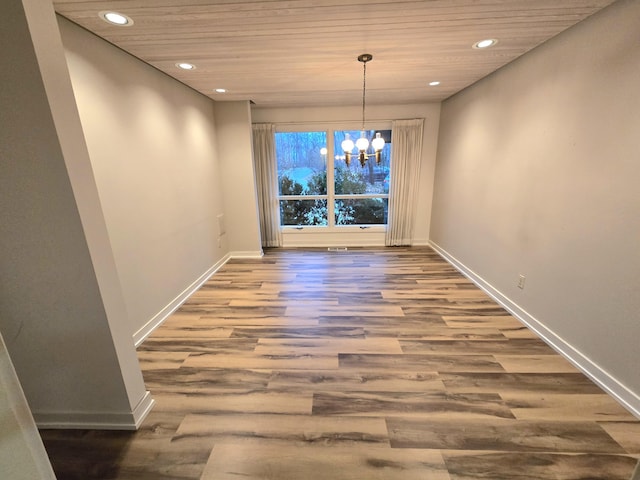 unfurnished dining area featuring wood ceiling, wood-type flooring, and an inviting chandelier