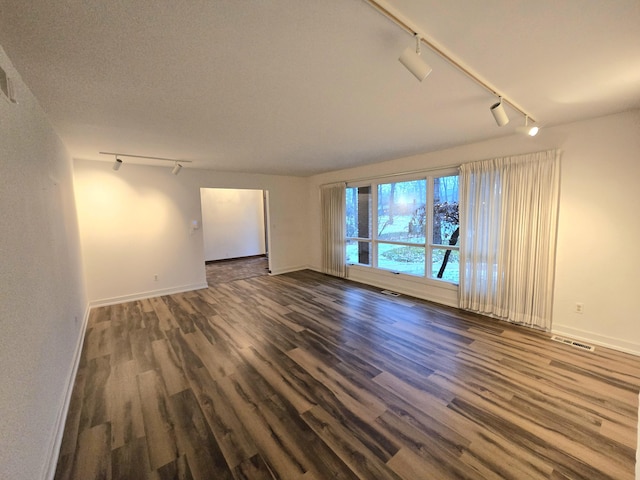 spare room featuring hardwood / wood-style floors and track lighting