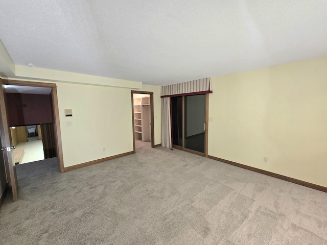 empty room with carpet floors and a textured ceiling