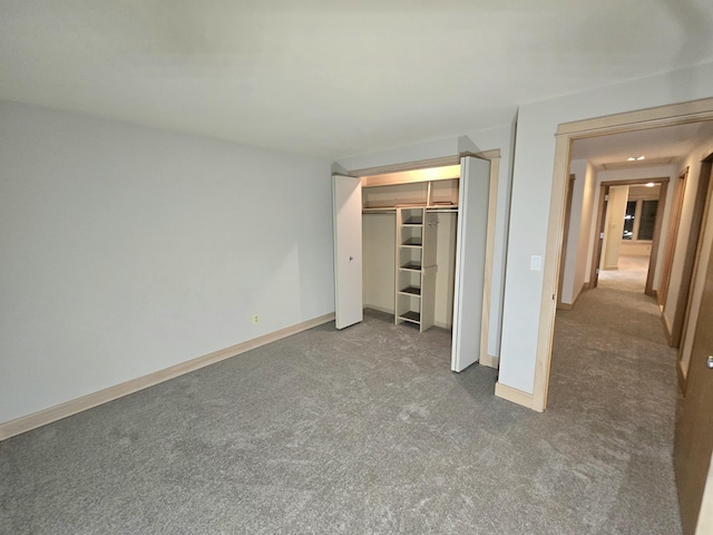 unfurnished bedroom with dark colored carpet and a closet