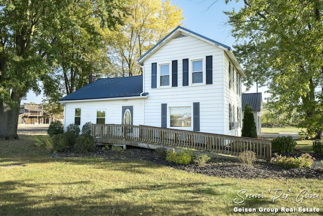 rear view of house with a yard and a wooden deck