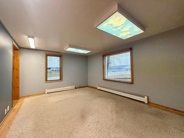 unfurnished room featuring light carpet and a baseboard heating unit