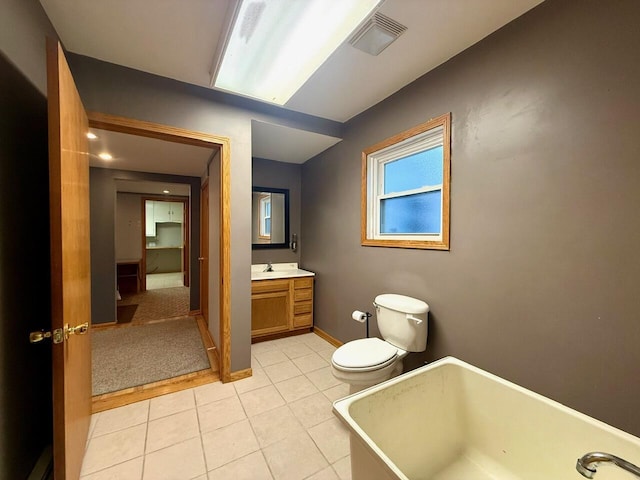 bathroom featuring a bathing tub, tile patterned flooring, vanity, and toilet