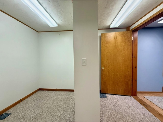 basement featuring crown molding and light carpet