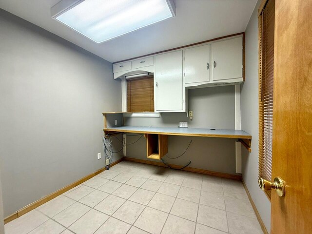 kitchen with light tile patterned flooring, built in desk, and kitchen peninsula