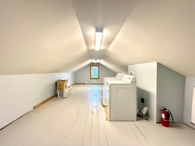 bonus room featuring washing machine and clothes dryer, light hardwood / wood-style flooring, baseboard heating, and vaulted ceiling