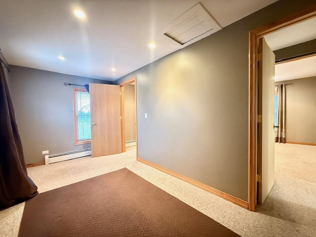 carpeted spare room featuring a baseboard heating unit