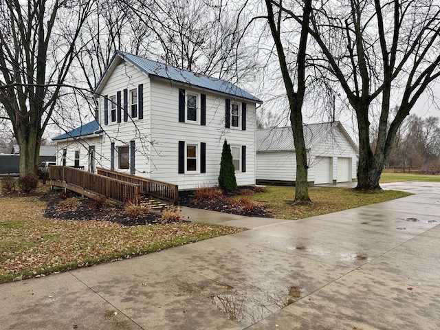 view of front facade featuring an outbuilding, a front yard, and a garage