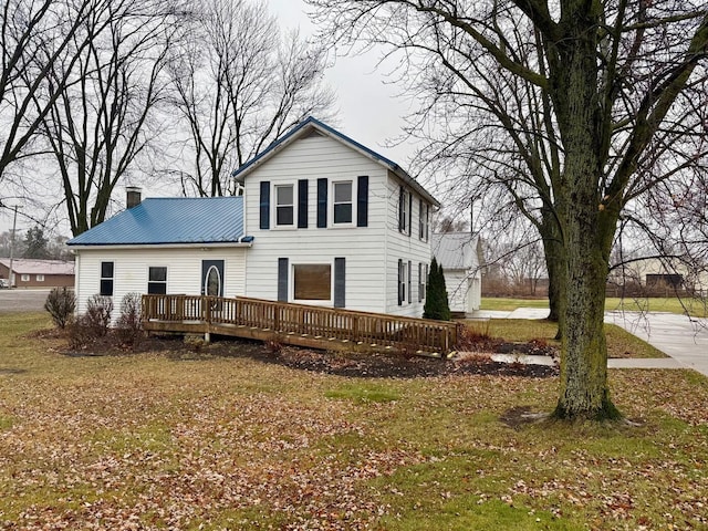 view of front of home featuring a front lawn and a wooden deck