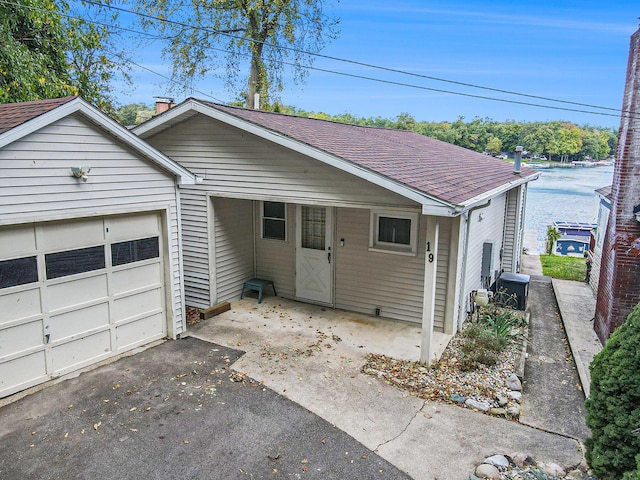 view of front of house featuring a garage and a water view