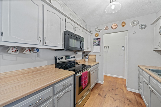 kitchen featuring light hardwood / wood-style floors, a textured ceiling, white cabinetry, and stainless steel range with electric cooktop